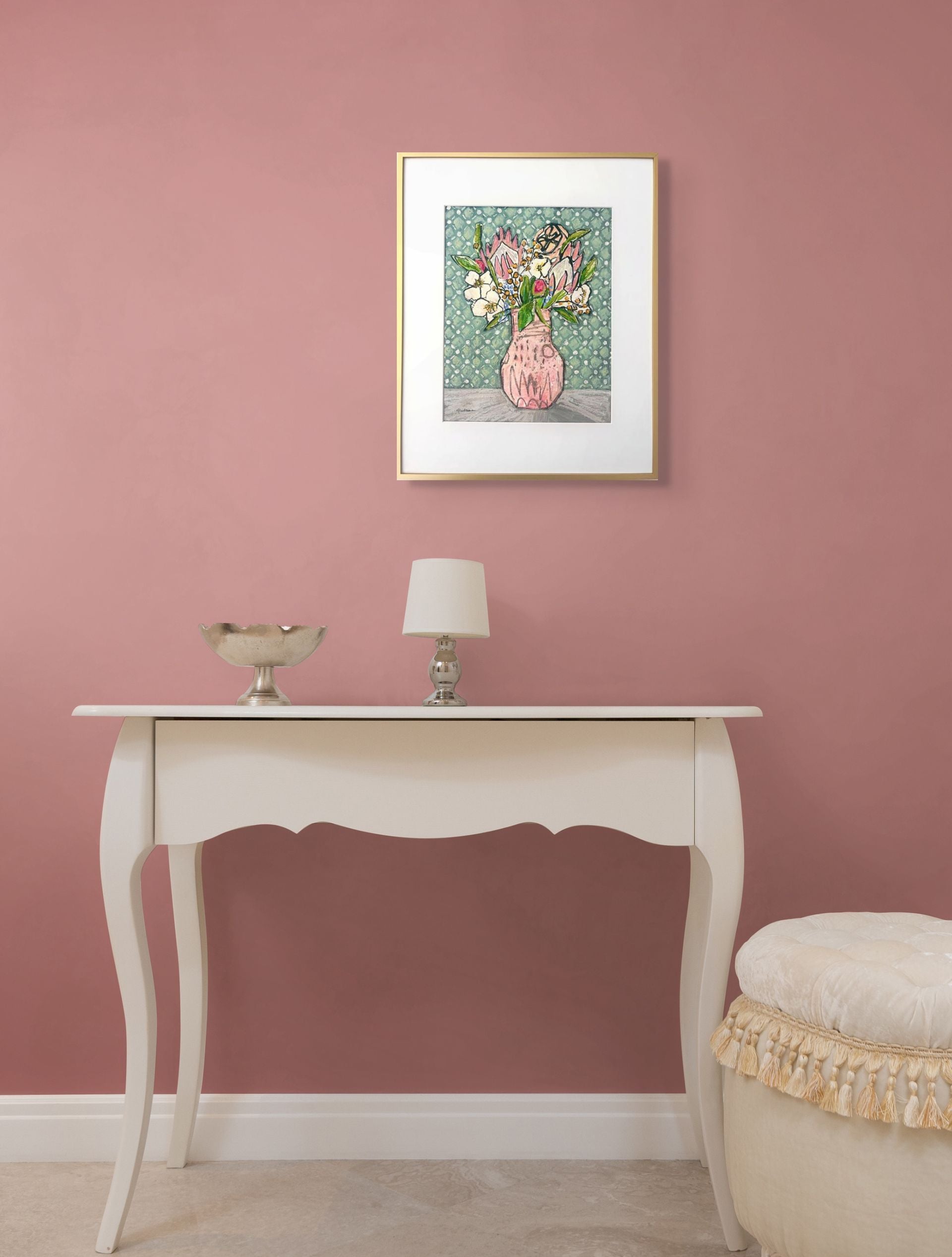 White console table with decorative items against a light pink wall with a framed Protea in Pink.