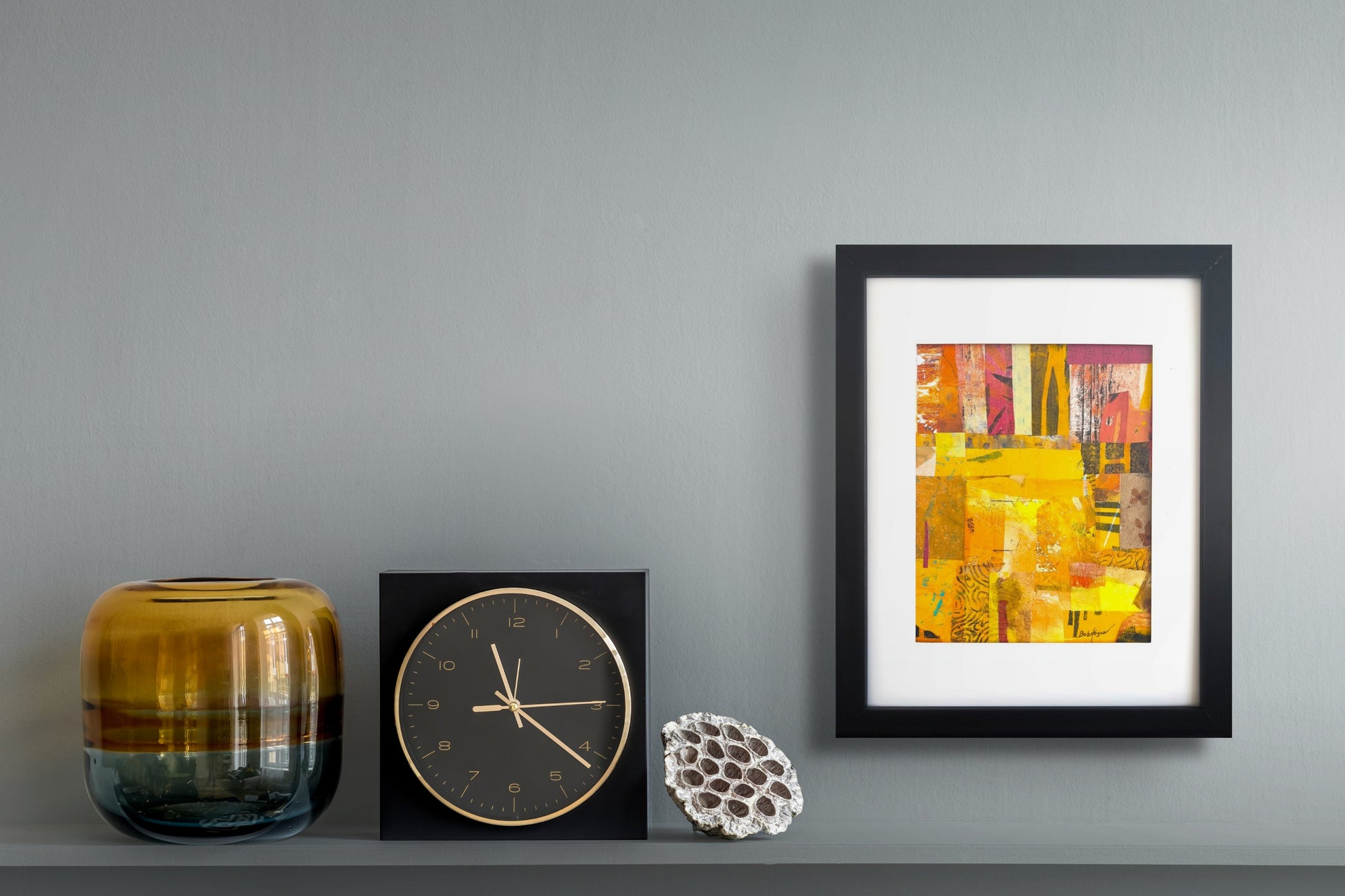 Colorful collage in strong yellows and reds using Bob Hogue's painted pieces titled "Safari" in a black wood frame with a white mat; shown in situ