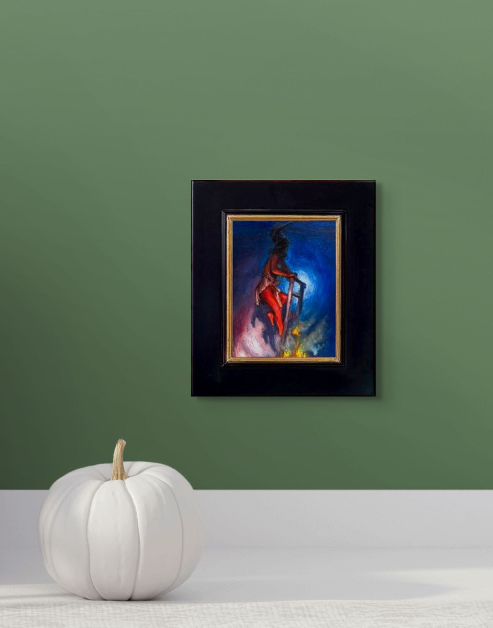 Impressionistic depiction of a person climbing a ladder appearing to go nowhere with a blue and purple background; shown with 2" black wood frame and in situ on a green wall above a white pumpkin