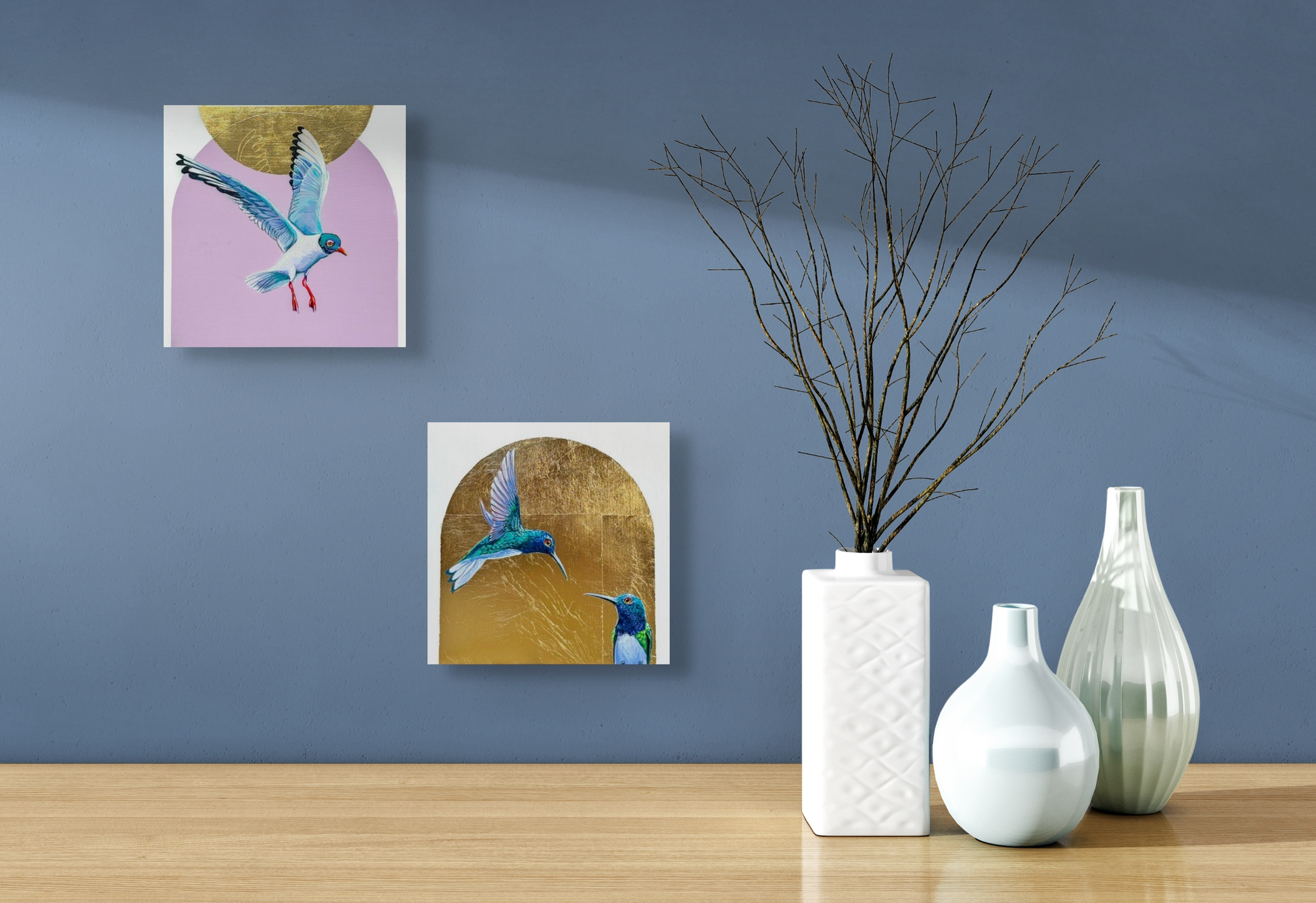 Crossing Swords and Suspended, two hummingbird paintings make a nice set above this table adorned with white vases