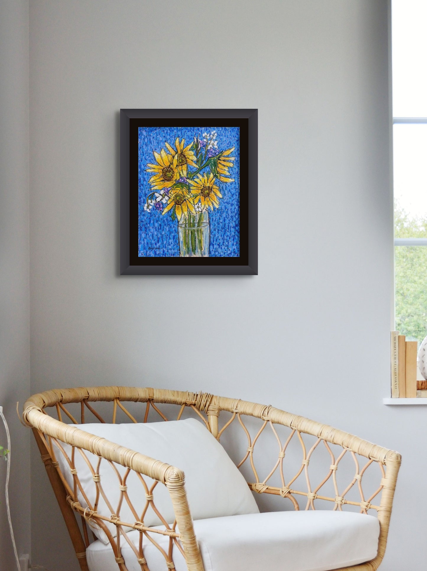 A clear vase filled with water holds a bouquet of bright yellow sunflowers against a royal blue textured background; artist Rachel Bunteman; shown framed in situ